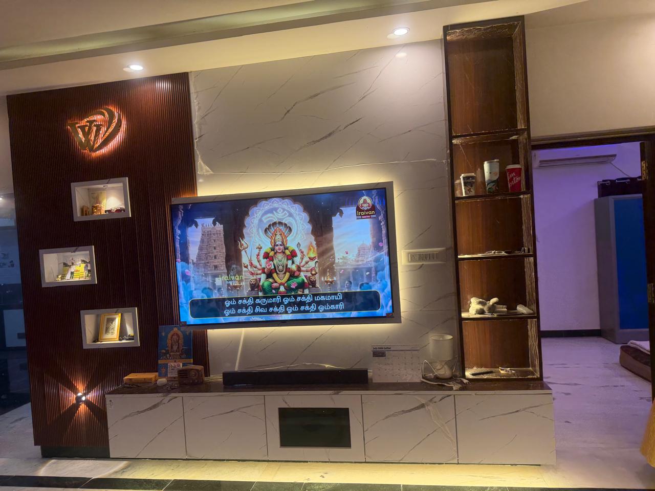 Fluted wood panel TV unit and marble wall in Trichy residence